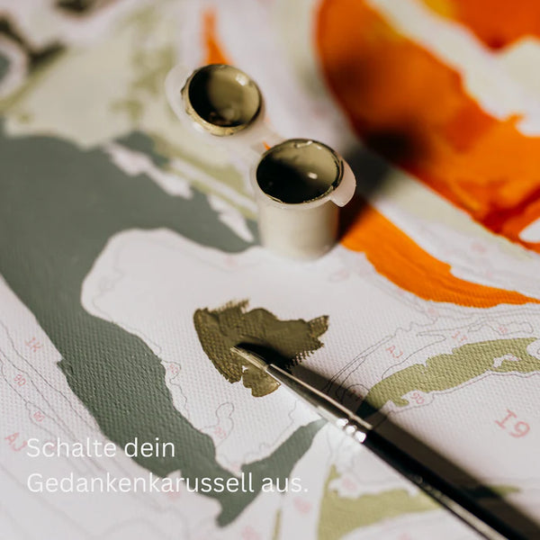 Malen-nach-Zahlen Leinwand mit Pinsel und Farbtöpfen, Text in Deutsch lautet: Schalte dein Gedankenkarussell aus.