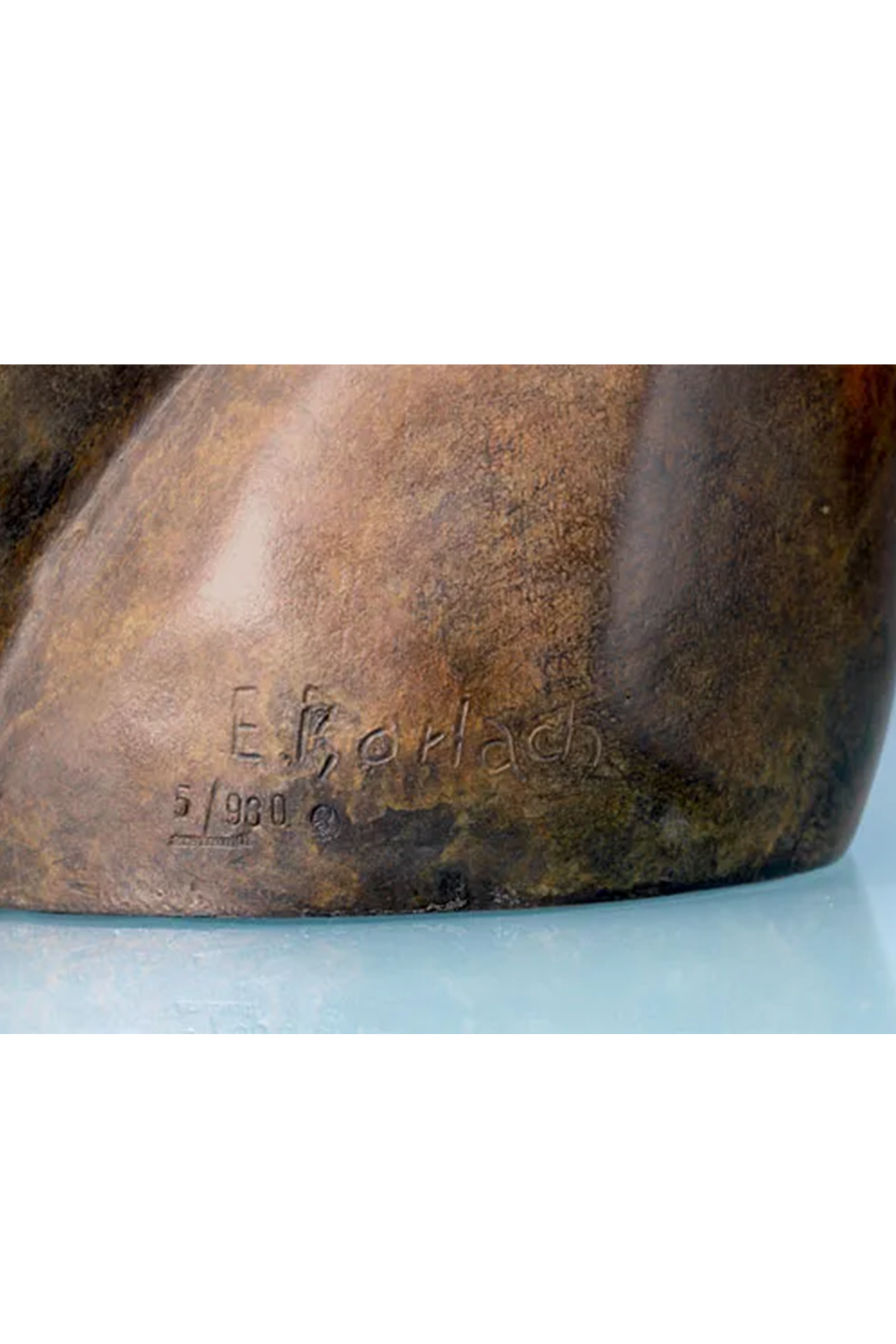 Nahaufnahme eines Sockels einer Bronzeskulptur mit der eingravierten Signatur E. Karbach und der Nummer 5/980.