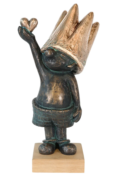 Bronzeskulptur in Form eines kleinen Königs mit viel zu großer Krone, der ein Herz in die Höhe hält und eine Karohose trägt. 