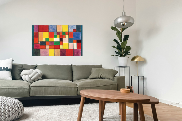 Das Gemälde von Paul Klees „Harmonie der nördlichen Flora“ (1927): Abstrakte Kunst mit bunten Rechtecken und Quadraten unterschiedlicher Größe, die in einem Raster auf Leinwand angeordnet sind - abgebildet im einem Wohnzimmer über einer grünen Couch hängend. 