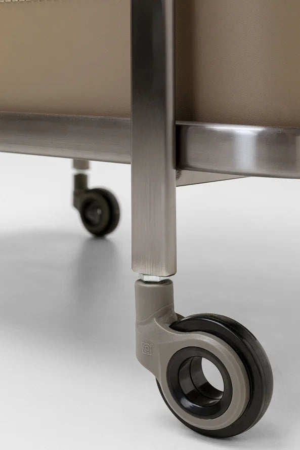 Eine Nahaufnahme von zwei grauen Lenkrollen, die an den Beinen eines Metallwagens auf einem glatten Boden befestigt sind.