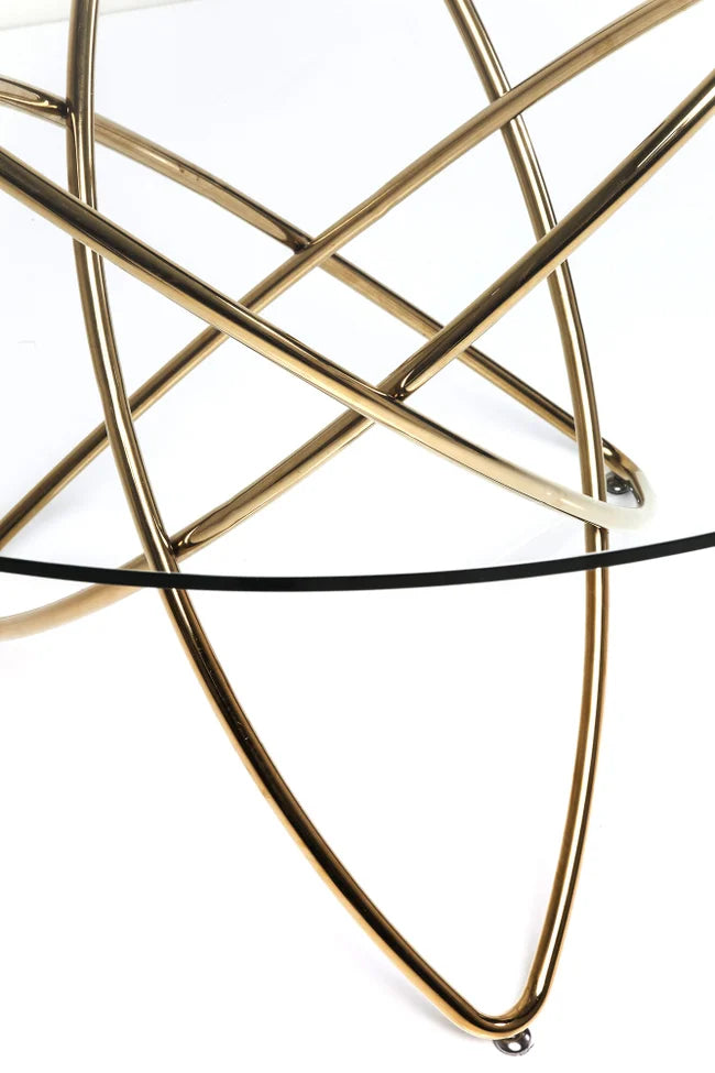 Eine Nahaufnahme des Tisch Molekular Glastisch mit einem goldenen geometrischen Metallsockel mit sich kreuzenden geschwungenen Linien und modernem Design vor einem weißen Hintergrund.