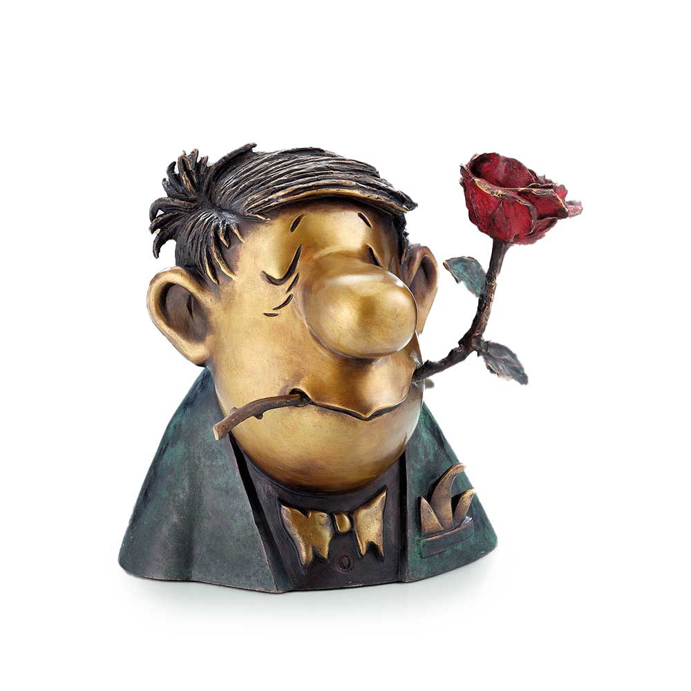 Skurrile Skulptur eines Mannes im Anzug mit traurigem Gesichtsausdruck, der eine rote Rose im Mund hält.