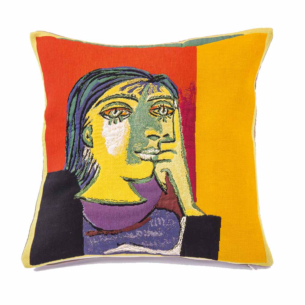 Farbenfrohes Kissen mit abstraktem Gesichtsdesign, inspiriert vom Kunststil Picassos, auf einem roten, orangefarbenen und gelben Hintergrund.