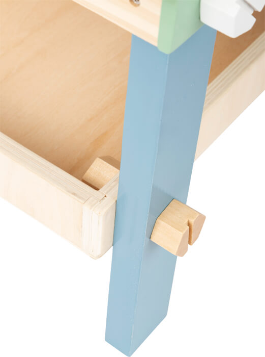Nahaufnahme der Werkbank kompakt „Nordic“ mit Holzschublade, blauem Bein und einem Holzstift zur Sicherung der Ecke.