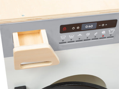 Nahaufnahme des modularen XL-Bedienfelds der Kinderküche mit Tasten, Display und einer Waschmittelschublade aus Holz.