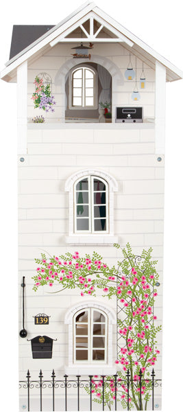 Das Puppenhaus Stadtvilla ist ein weißes Puppenhaus mit rosa Blumenranken, Fenstern, einem Balkon und dekorativen Außendetails.