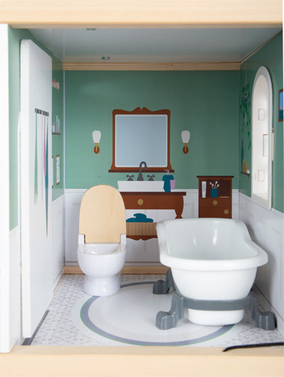Das Puppenhaus Stadtvilla verfügt über ein Miniatur-Puppenhausbadezimmer mit Toilette, Badewanne und Waschtisch vor grünen Wänden.