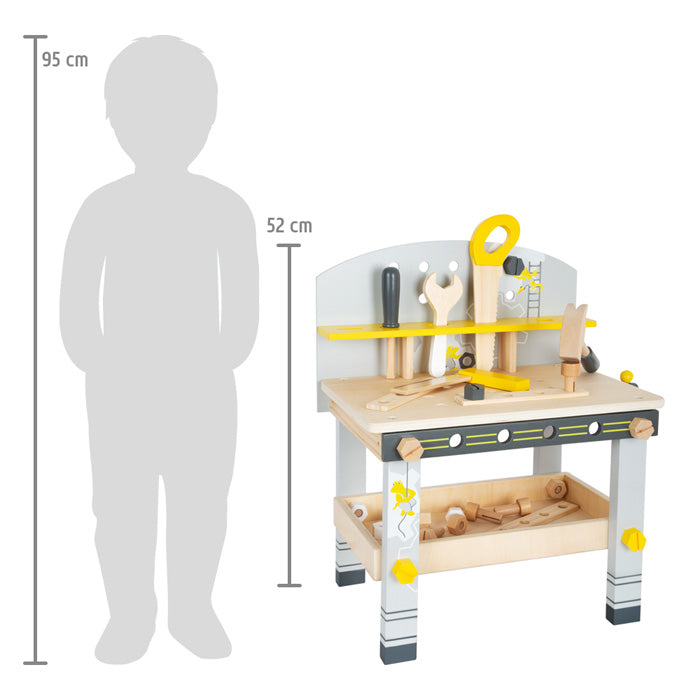 Die Werkbank kompakt „Miniwob“, eine Kinder-Holzwerkbank mit Spielzeugwerkzeugen, wird neben einer 95 cm großen Silhouette als Maßstab präsentiert.