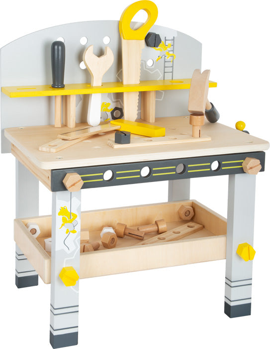 Die Werkbank kompakt „Miniwob“ ist eine Spielzeug-Werkbank aus Holz mit Werkzeugen wie Säge, Schraubenschlüssel, Hammer und Schrauben auf und unter dem Tisch.