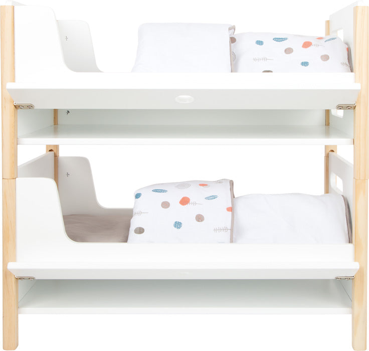 Das Puppenhochbett „Little Button“ ist ein weißes Puppenhochbett aus Holz, von vorne abgebildet mit bunt gemusterter Bettwäsche.