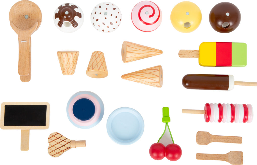 Die Eistheke „fresh“ bietet verschiedene Dessert-, Obst- und Küchenutensilien aus Holzspielzeug, die auf weißem Hintergrund angeordnet sind.