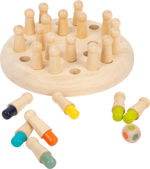 Farben-Memo: Ein Memory-Spiel aus Holz mit einem runden Brett, losen Stiften und einem farbigen Würfel auf weißem Hintergrund.