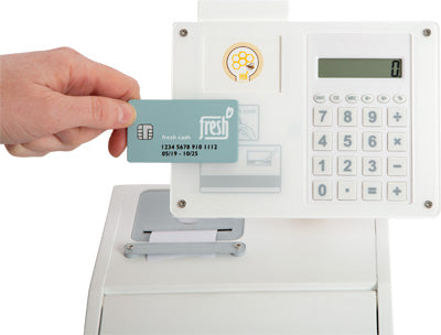 Eine Hand hält eine Kreditkarte in der Nähe des weißen Bezahlterminals „fresh“ der Kasse mit Tastatur und Display.