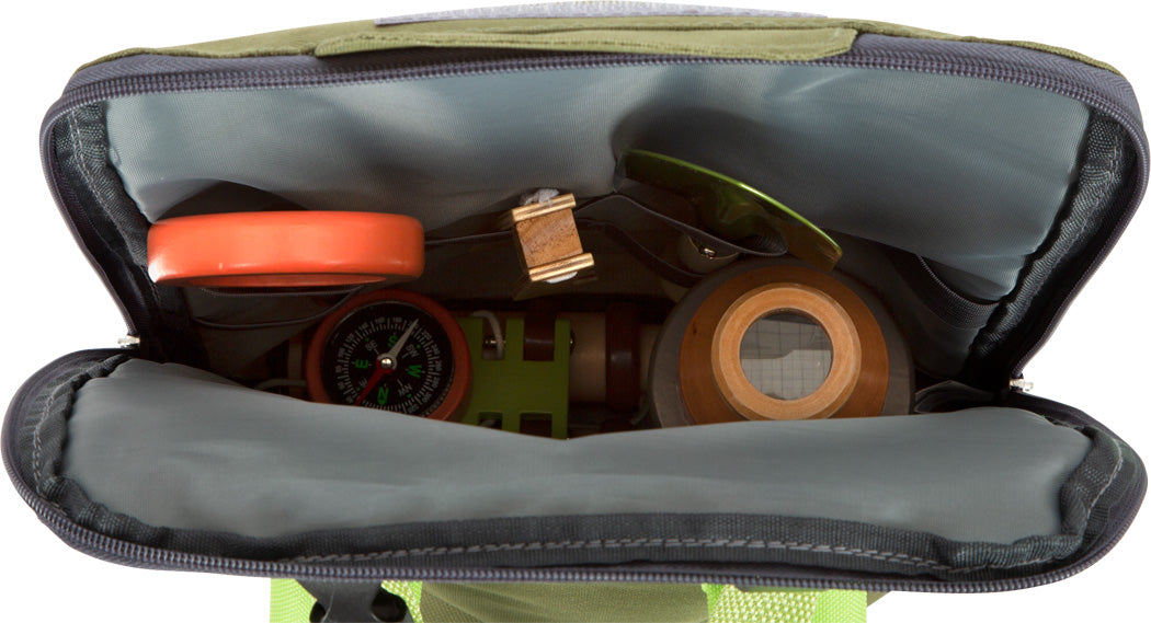 Draufsicht auf einen geöffneten Entdeckerrucksack „Discover“ mit Kompass, Spule, Holzbehälter und Campingausrüstung.