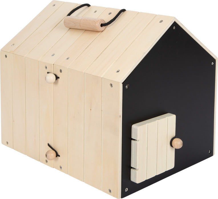Der Hasenstall mit Auslauf ist ein Holzhaus mit einem oberen Griff und einer kleinen Seitentür, gefertigt aus hellem Holz.
