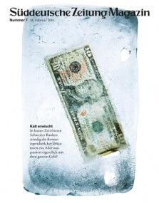 Ein verwitterter US-Dollarnotenschein ist in einem Eisblock auf einer Zeitschriftenhülle eingefroren.