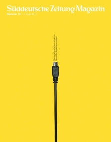 Ein schwarzes USB-Kabel steht aufrecht vor einem einfarbig gelben Hintergrund mit weißem Text am oberen Rand.