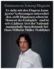 Ein Mann mit dunklem Haar steht vor einem dunklen Hintergrund mit deutschem Text über ihm auf einem Zeitschriftencover.
