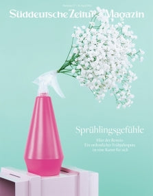Eine rosafarbene Sprühflasche hält weiße Schleierkrautblüten vor einem mintgrünen Hintergrund.