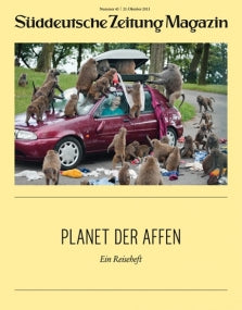 Ein rotes Auto, umgeben von vielen Pavianen, mit Menschen darin, auf dem Cover des Süddeutsche Zeitung Magazins.