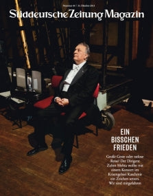 Ein älterer Mann im Smoking sitzt hinter der Bühne auf einem roten Stuhl, abgebildet auf dem Cover des Süddeutsche Zeitung Magazins.