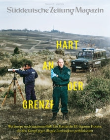 Drei Grenzbeamte stehen in der Nähe eines Polizeifahrzeugs in einer ländlichen Gegend; der Text auf der Titelseite der Zeitschrift überlagert das Bild.