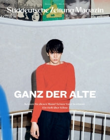 Auf dem Titelbild des Süddeutsche Zeitung Magazins steht eine Person in einem roten Pullover vor einer grauen Wand.