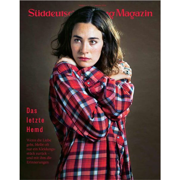 Eine Frau in einem rotkarierten Hemd umarmt sich selbst und schaut zur Seite; Titeltext des Süddeutsche Zeitung Magazins auf Deutsch.