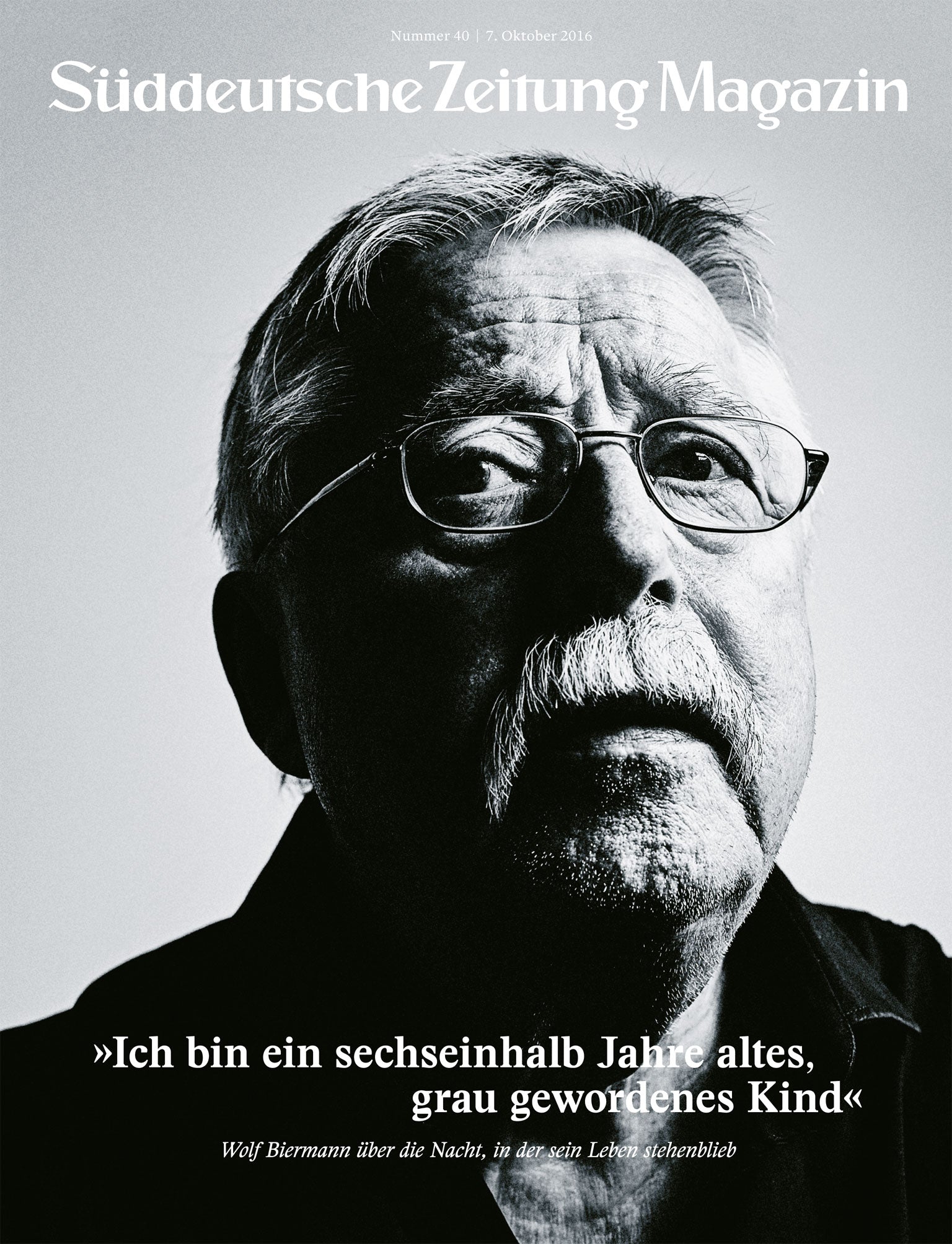 Schwarz-Weiß-Porträt eines älteren Mannes mit Brille und Schnurrbart, der leicht nach oben blickt.