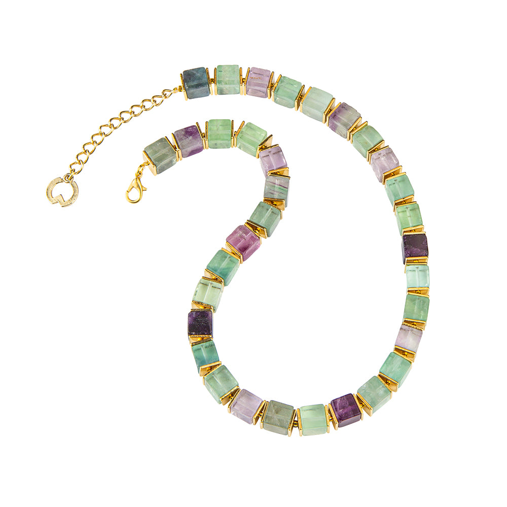 Eine Perlenkette mit quadratischen grünen, violetten und blauen Steinen, akzentuiert durch goldene Abstandshalter und einen goldenen Kettenverschluss.