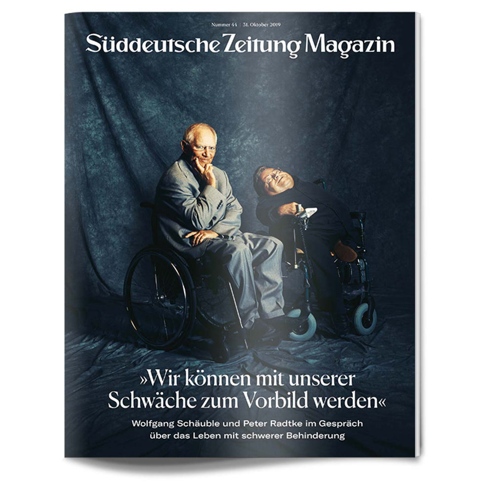 Auf dem Titelbild des Süddeutsche Zeitung Magazins sitzen zwei Männer in Rollstühlen vor einem dunklen Hintergrund zusammen.