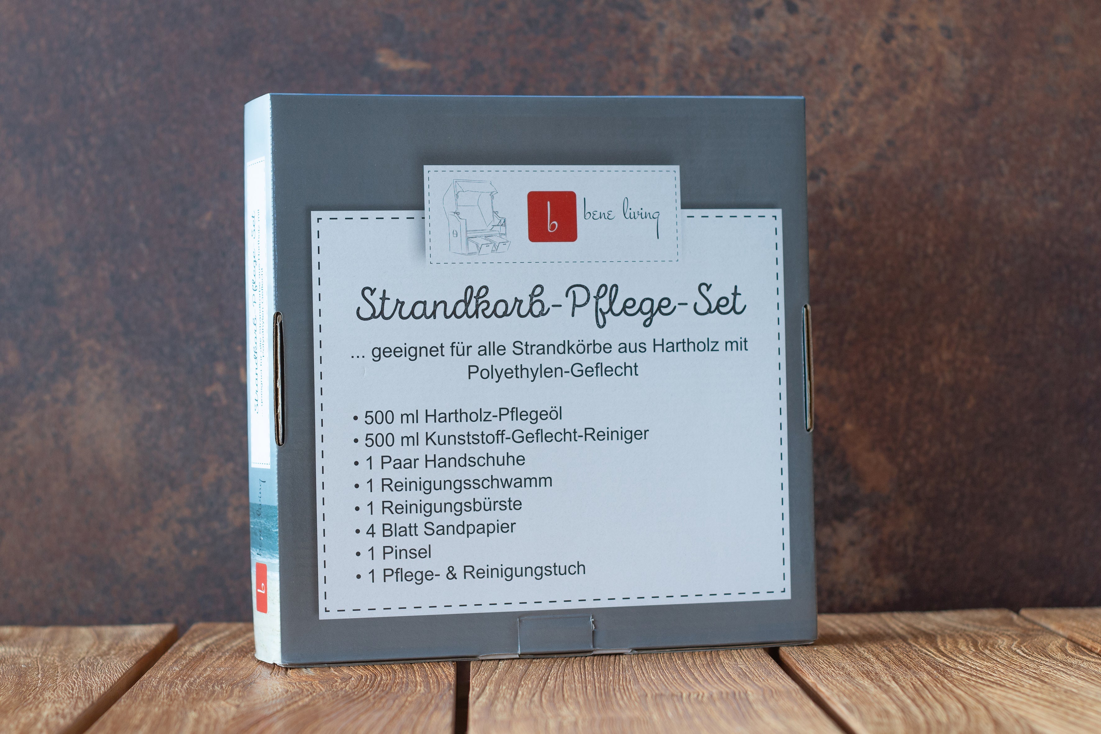 Eine Schachtel mit der Aufschrift „Strandkorb-Pflege-Set“ und einer Liste von Reinigungsartikeln auf einer Holzoberfläche.