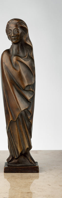 Bronzeskulptur einer stehenden Frau in wallender Kleidung auf einem kleinen quadratischen Sockel.