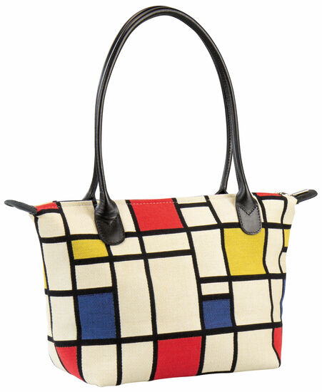 Eine Einkaufstasche mit schwarzen Griffen und einem geometrischen Muster aus roten, gelben, blauen, weißen und schwarzen Linien.