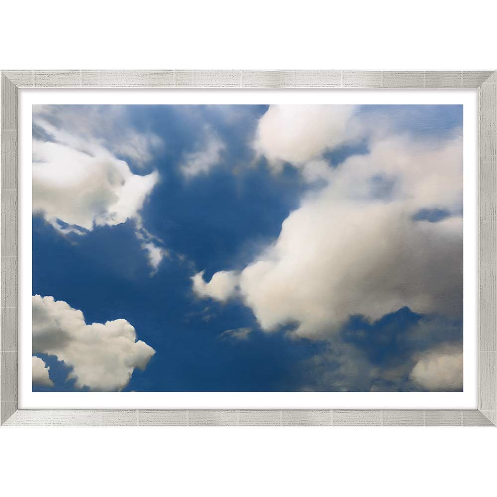 Große weiße Wolken, die über einen strahlend blauen Himmel verstreut sind, eingerahmt von einem weißen strukturierten Rand.
