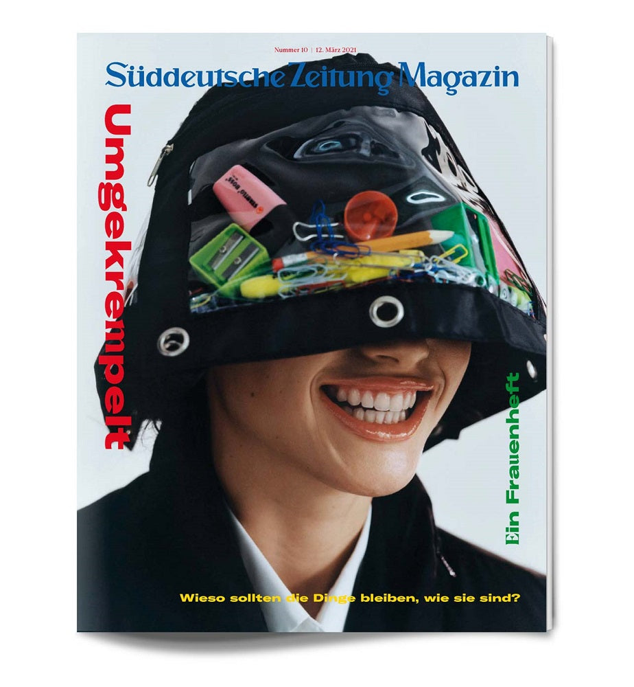 Lächelnde Person mit einem Hut, der mit verschiedenen Büromaterialien bedeckt ist, auf einer Titelseite des Süddeutsche Zeitung Magazins.