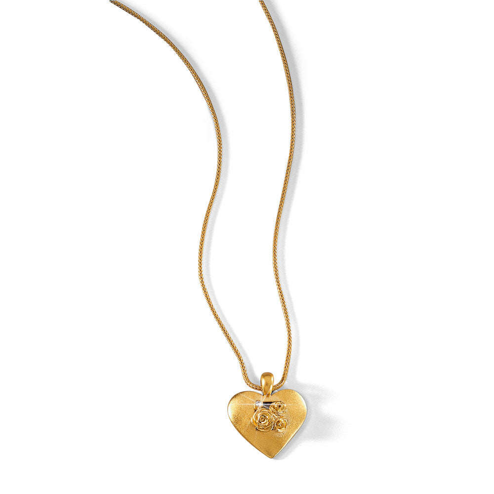Goldener herzförmiger Medaillonanhänger mit Rosenmuster an einer dünnen Goldkette, abgebildet auf weißem Hintergrund.