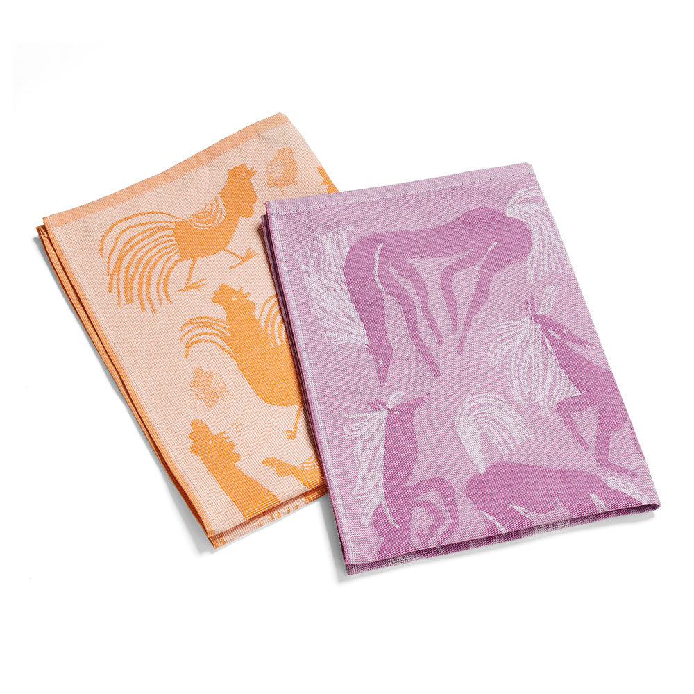 Zwei gefaltete Tücher, eines orange mit Hahnenmotiven, eines violett mit abstrakten Vogelmustern.
