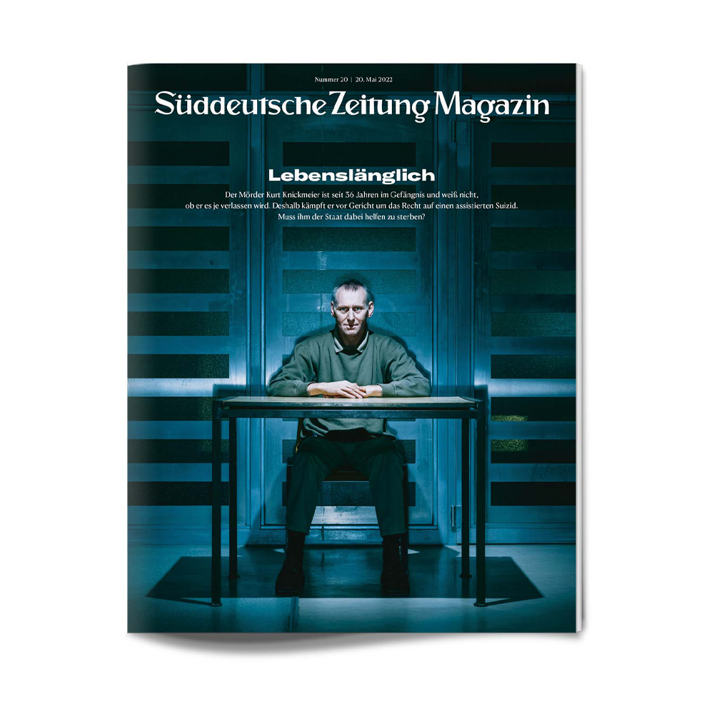 Auf der Titelseite des Süddeutsche Zeitung Magazins sitzt ein Mann allein an einem Tisch in einem schummrigen Raum.