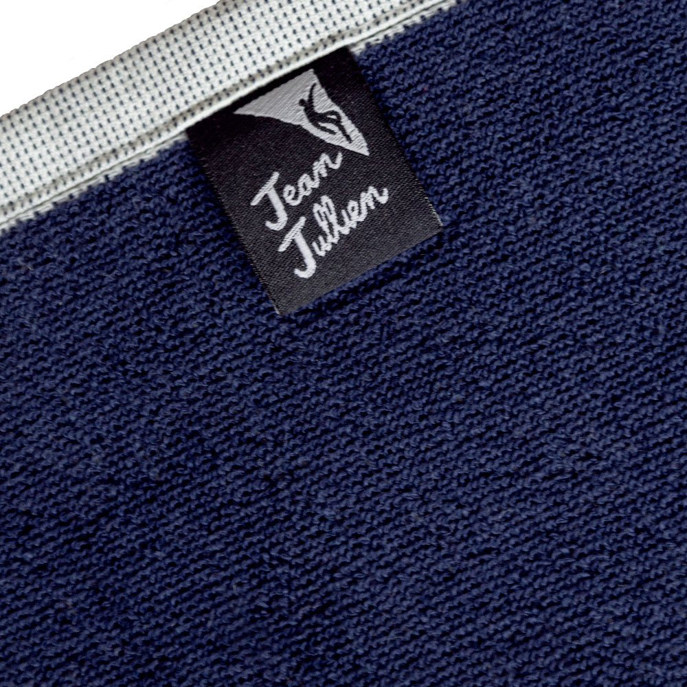 Nahaufnahme eines marineblauen Handtuchs mit einem auf den Rand aufgenähten schwarzen Jean Julien-Etikett.