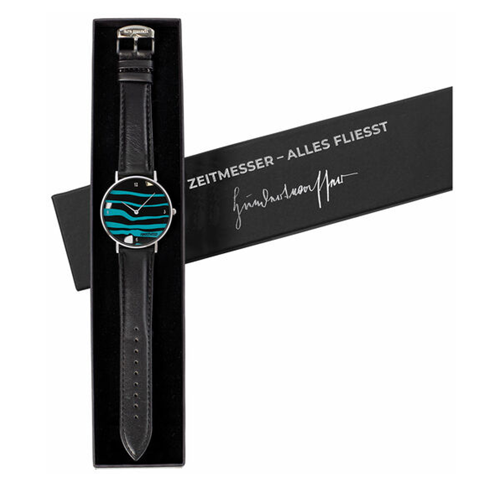 Schwarze Armbanduhr mit blaugrünem Wellendesign in einer Schachtel mit der Aufschrift „Zeitmesser – Alles Fliesst“ und einer Signatur.