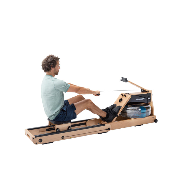 Ein Mann benutzt ein hölzernes Wasserrudergerät, indem er den Griff zieht, während er auf dem Schiebesitz sitzt.