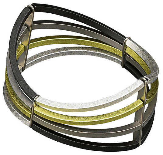 Geometrisches Metallarmband mit gebogenen schwarzen, silbernen und goldenen Bändern, die durch vertikale Balken verbunden sind.