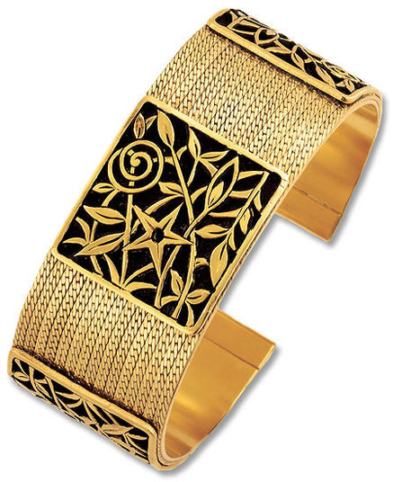 Breites goldenes Armreifarmband mit aufwendigen schwarzen Blumen- und geometrischen Mustern, die in die Oberfläche eingraviert sind.