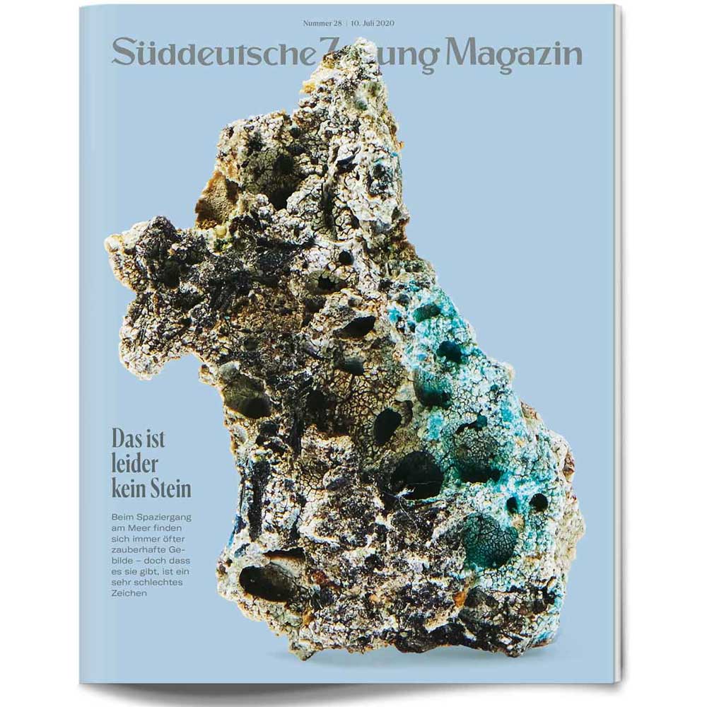Ein poröses, steinähnliches Objekt mit blauen und grünen Farbtönen auf einem hellblauen Zeitschriftenumschlag.