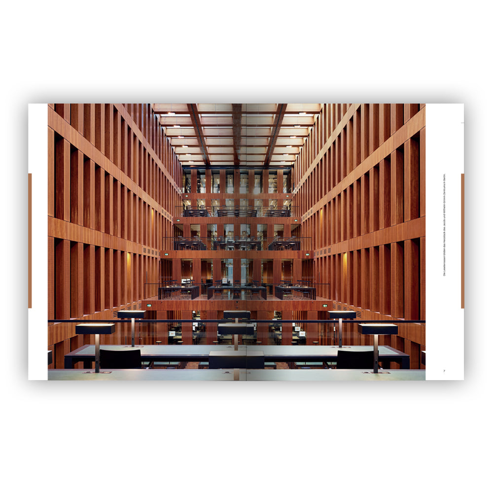 Eine moderne Bibliothekseinrichtung mit Holzwänden, hohen Regalen und Reihen von Schreibtischen und Stühlen.