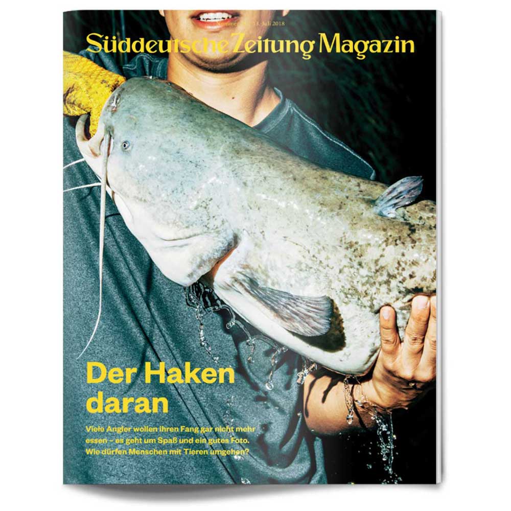 Person, die einen großen Wels hält, auf der Titelseite des Süddeutsche Zeitung Magazins, mit gelbem Text überlagert.
