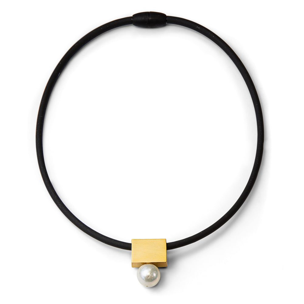 Schwarze Kordelkette mit einem goldenen quadratischen Anhänger und einer einzelnen Perle, die darunter hängt, auf weißem Hintergrund.