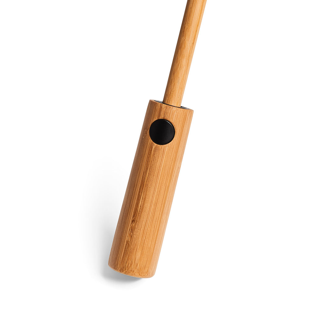 Ein Gerät mit Holzgriff und schwarzem Knopf, fotografiert auf weißem Hintergrund.